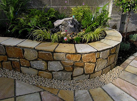 Raised planter bed constructed with rugged natural granite | Owen Chubb Garden Landscapers