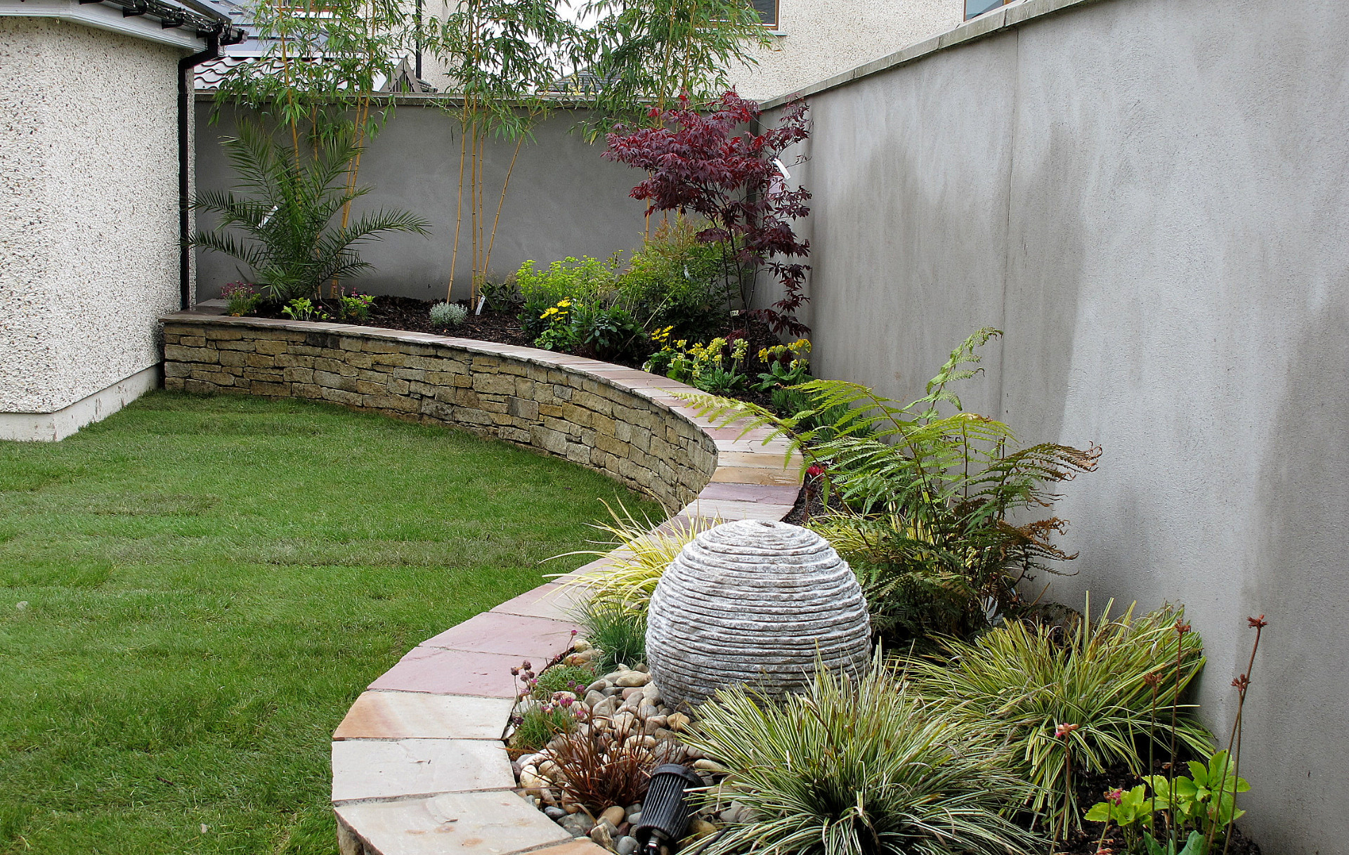 A sweeping Raised Planting Bed in natural stone | functional garden features