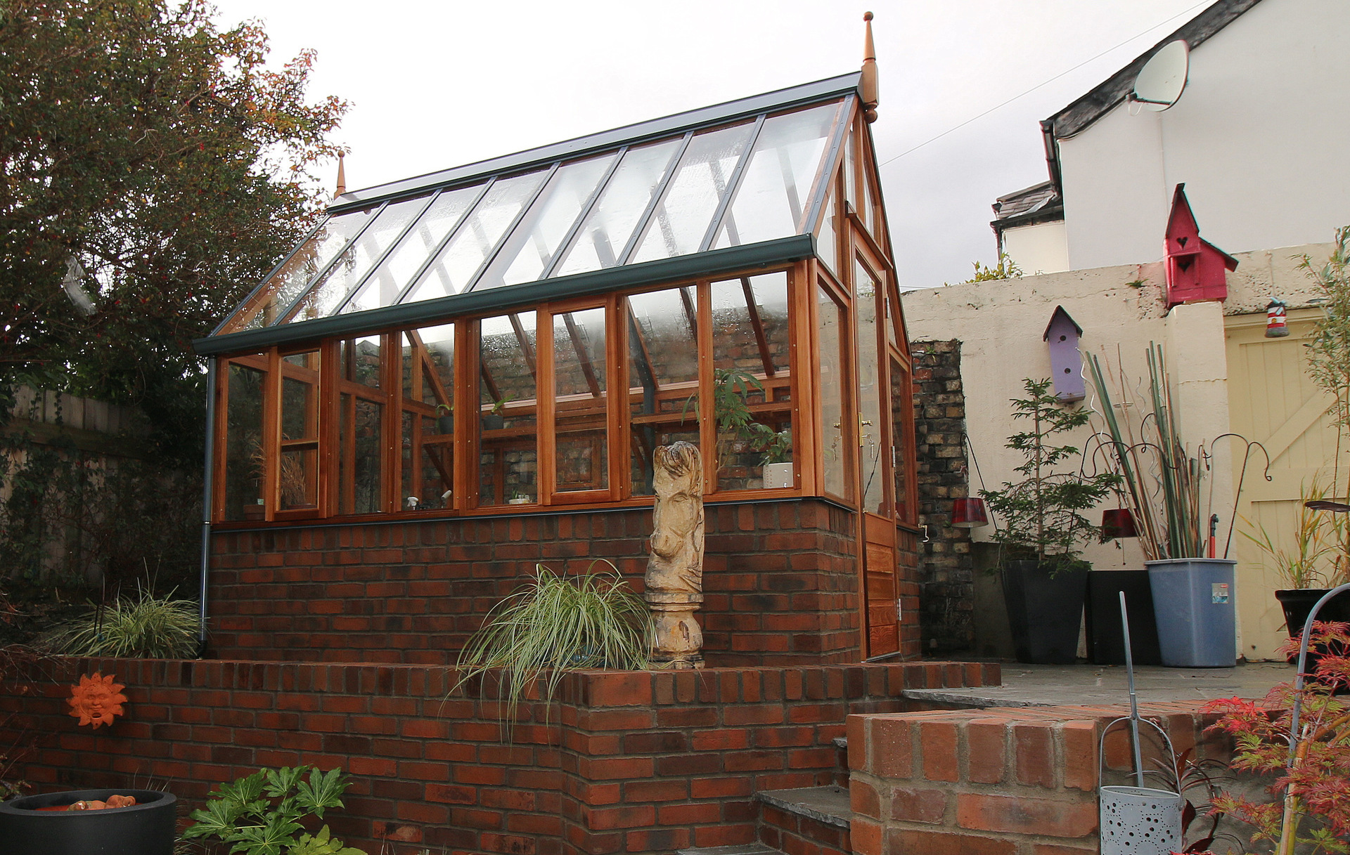 RHS Hyde Hall Victorian Greenhouse  installation in Rathgar, Dublin 6 with grey limestone patio & paving, retaining walls finished in red brick |  Owen Chubb Garden Landscapers