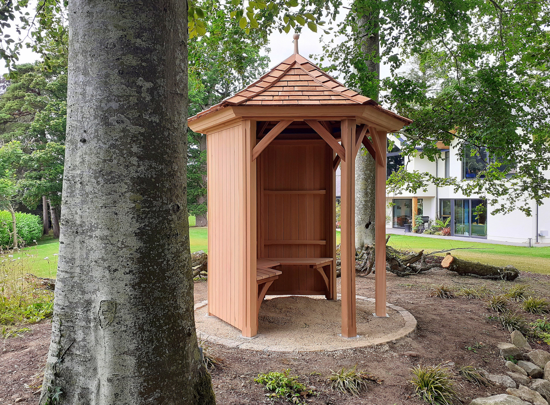 A stunning 1.8m six-sided Garden Gazebo by Victorian Garden Buildings, exceptionally well made in Western Red Cedar, with optional cedar bench. Supplied + Fitted by Owen Chubb Garden Landscapes Limited, in Maynooth, Co Kildare.