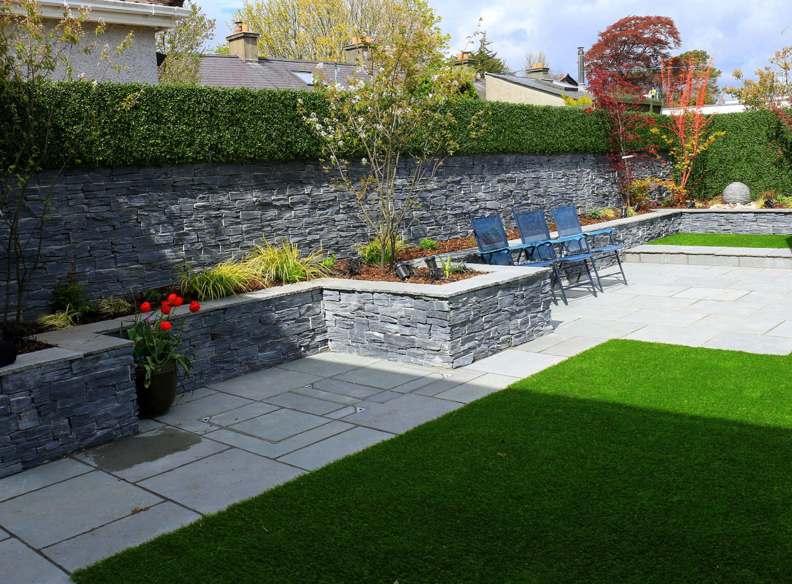 Stone cladding is used effectively on garden and raised planter bed walls