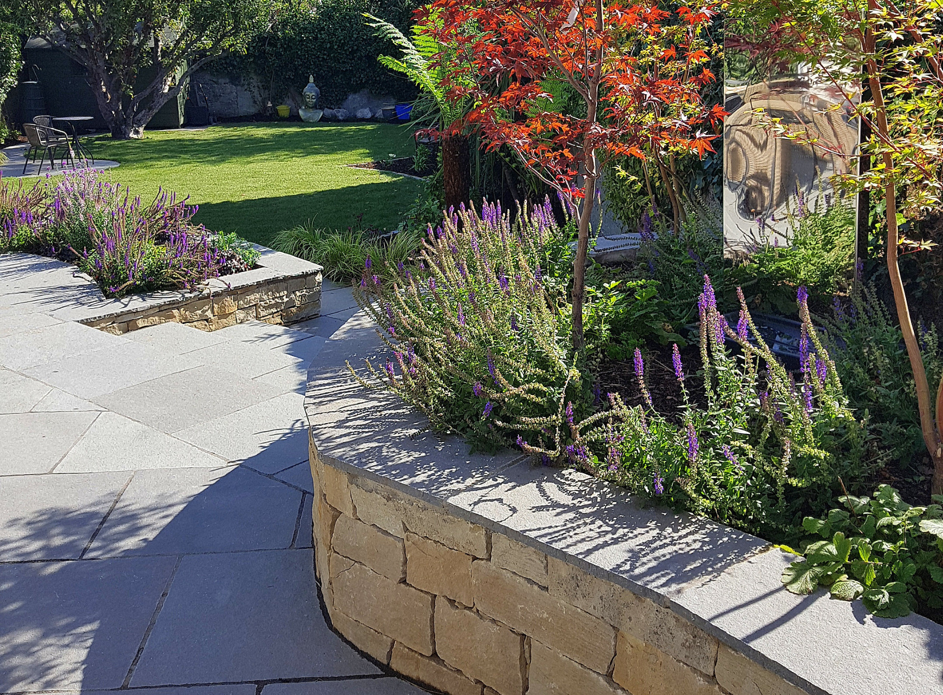 Sweeping raised planter beds in natural stone | Owen Chubb Landscapers