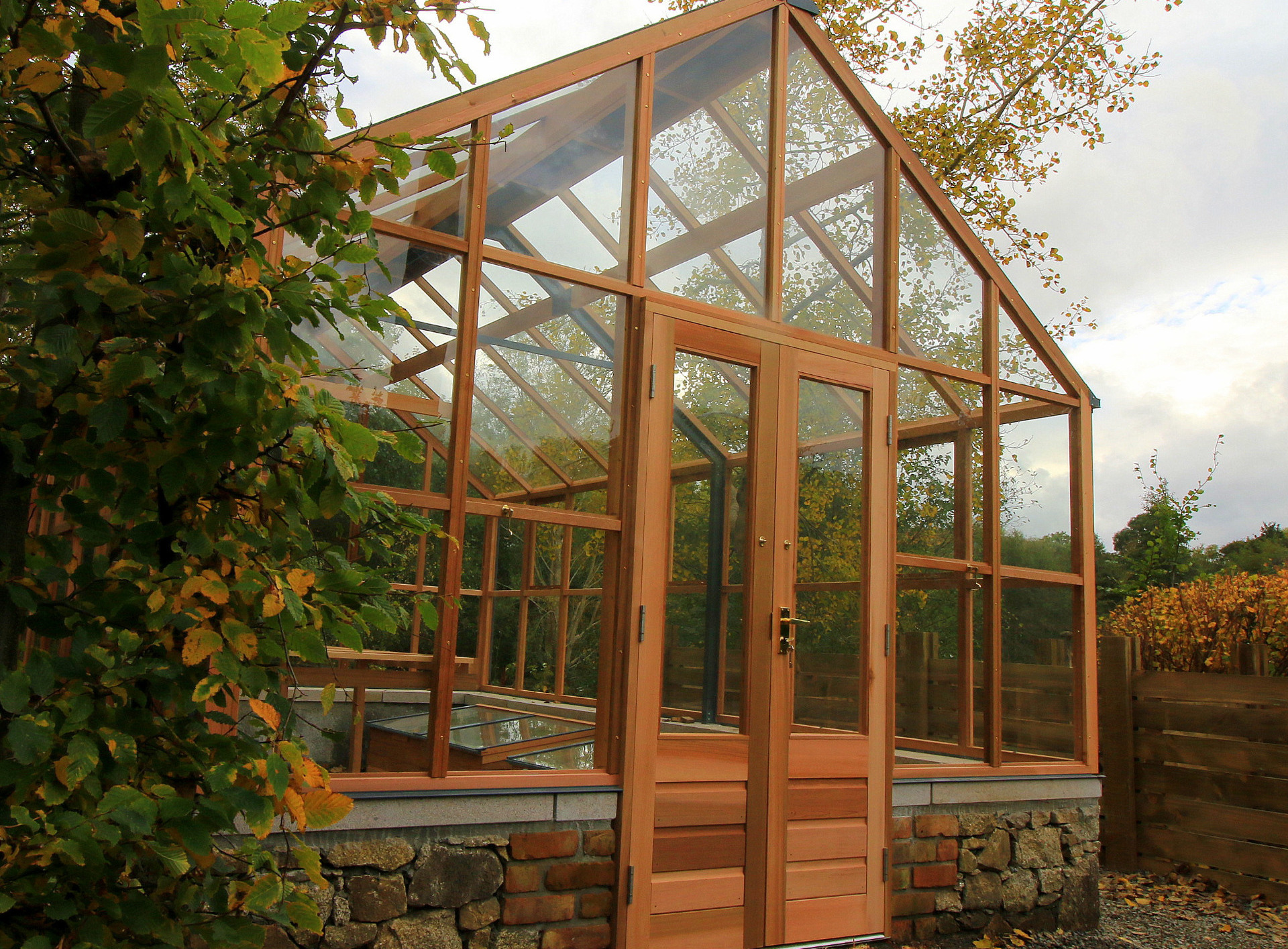 Gabriel Ash Classic Twelve Greenhouse on stone wall and with double door entrance  | the only timber greenhouses endorsed by the RHS | Owen Chubb  087-2306128